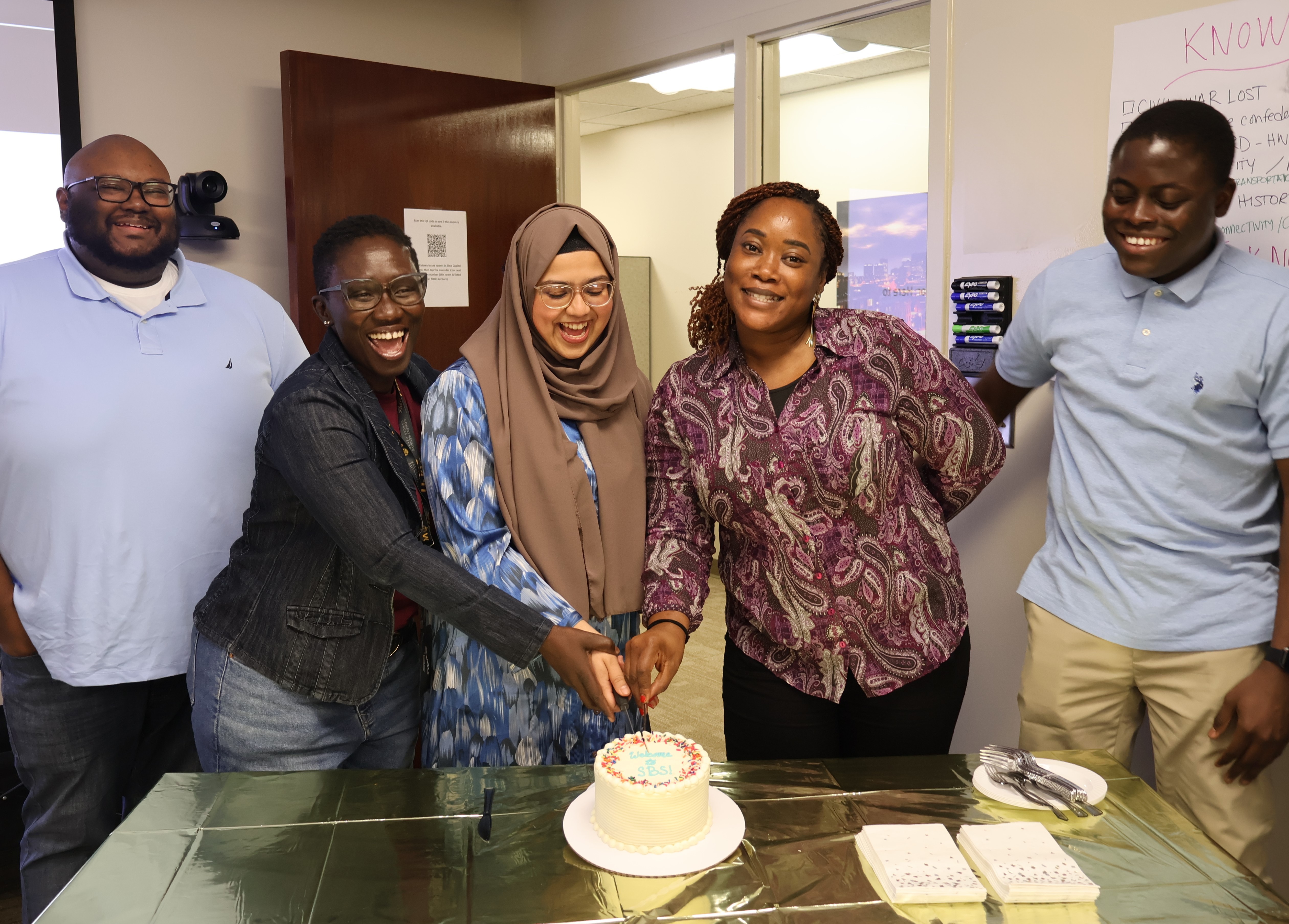 Five people stand around a table